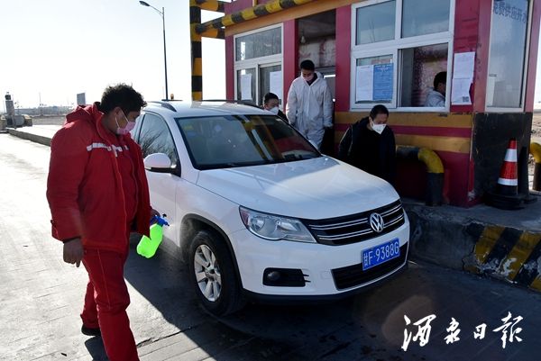 图为，瓜州县桥湾广汇疫情防控检查点，值守人员，对进出柳沟工业园区车辆及人员进行登记、测温和消毒。