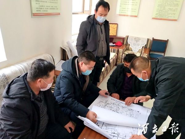 图为，头工村村干部看地图划分连片