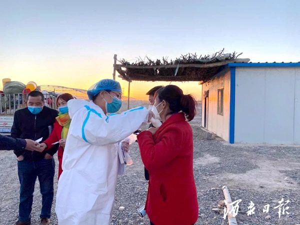 图为 青年志愿者为宁籍来瓜人员进行体温测量