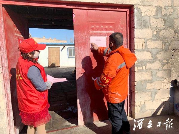 图为 青年志愿者在留观人员门口张贴温馨提示